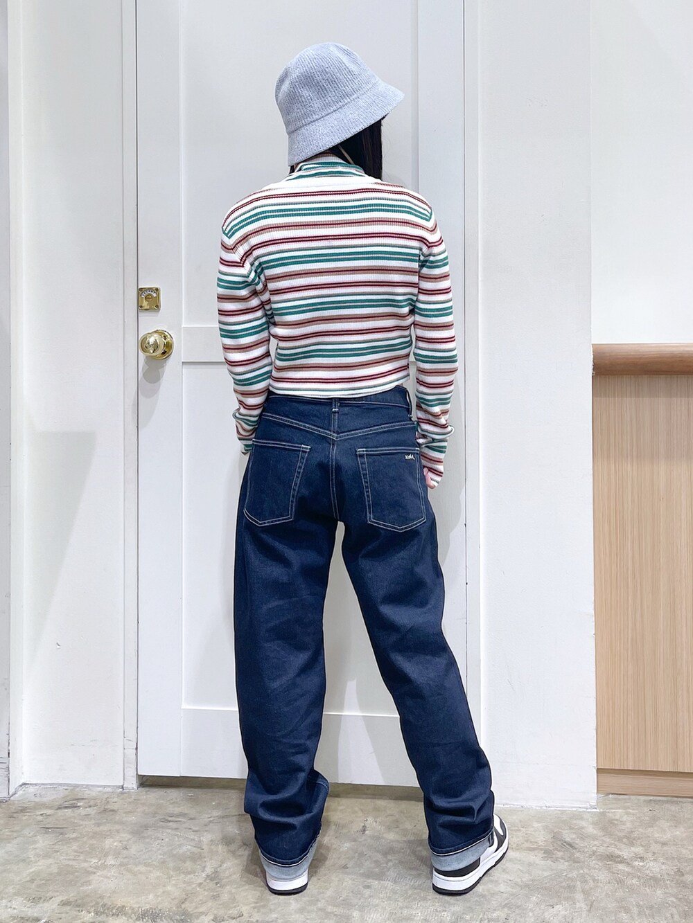 ホワイト系のカーディガン/ボレロ、ホワイト系のニット/セーター、ブルー系のデニムパンツを着用したレディースの秋コーディネートの3枚目の写真