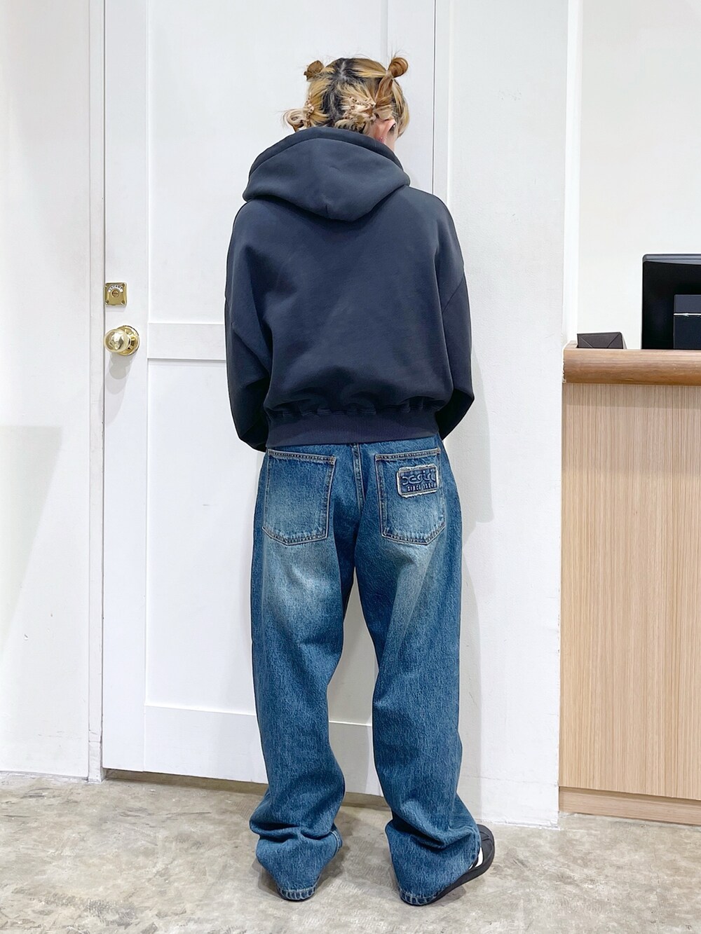 ブラック系のパーカー、ホワイト系のTシャツ/カットソー、ブルー系のデニムパンツを着用したレディースの春コーディネートの4枚目の写真