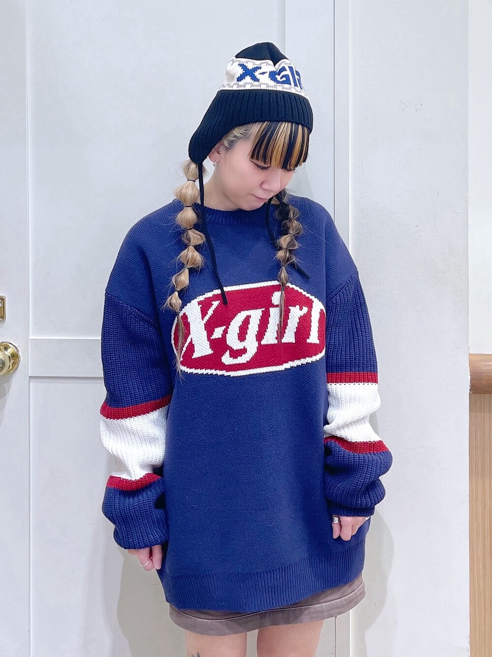 ブルー系のニット/セーター、グリーン系のスカート、ブラック系のブーツを着用したレディースの冬コーディネートの5枚目の写真