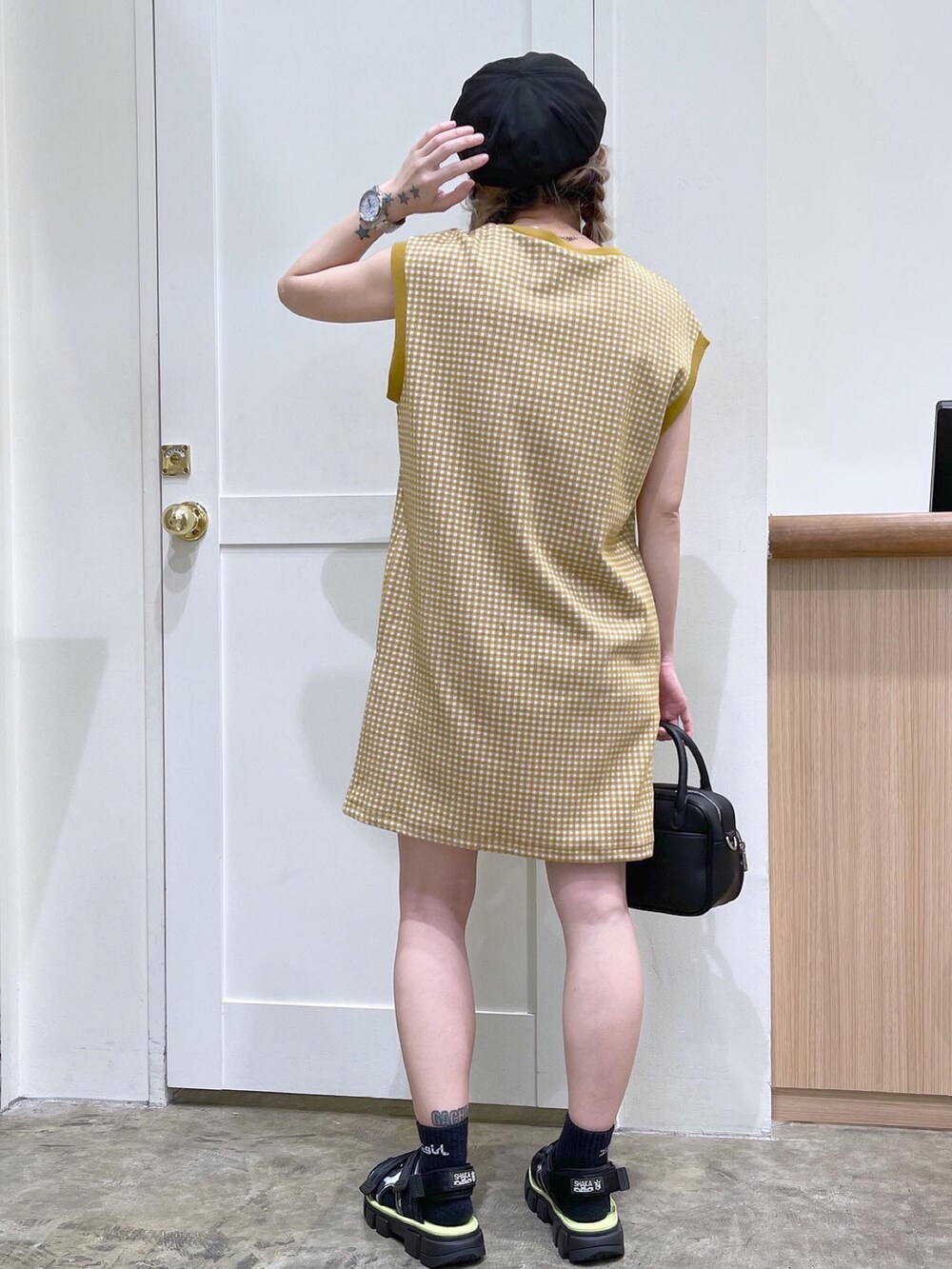 ベージュ系のワンピース、ブラック系のショルダーバッグ、ブラック系のサンダルを着用したレディースの夏コーディネートの5枚目の写真