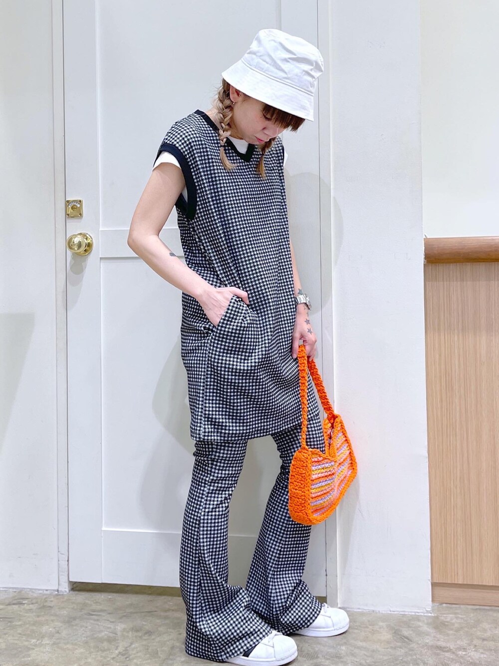 ブラック系のワンピース、ブラック系のその他パンツ、オレンジ系のハンドバッグを着用したレディースの夏コーディネートの3枚目の写真