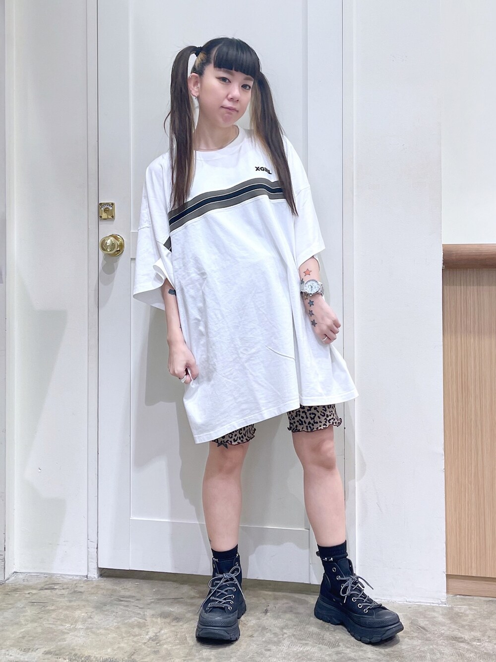 ブラック系のベスト、ホワイト系のワンピース、ブラック系のスニーカーを着用したレディースの夏コーディネートの5枚目の写真