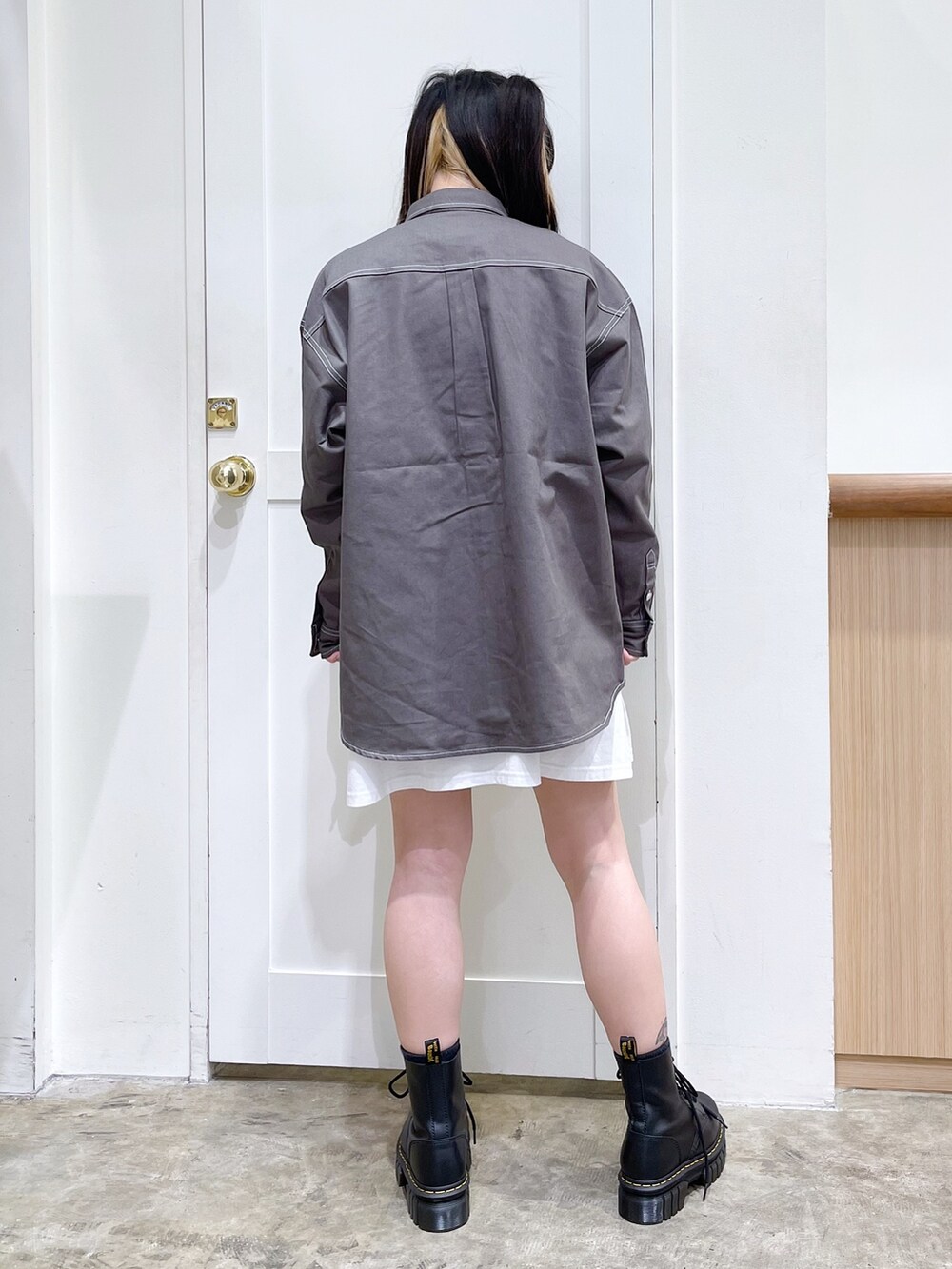 ブラック系のダウンベスト、グリーン系のシャツ/ブラウス、ホワイト系のワンピースを着用したレディースの秋コーディネートの5枚目の写真