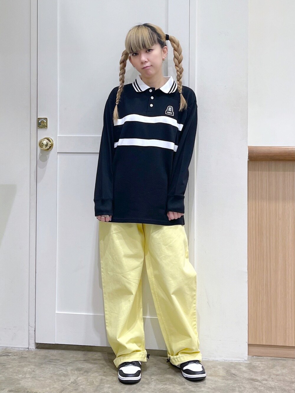 ブラック系のTシャツ/カットソー、イエロー系のその他パンツ、ブラック系のショルダーバッグを着用したレディースの春コーディネートの2枚目の写真