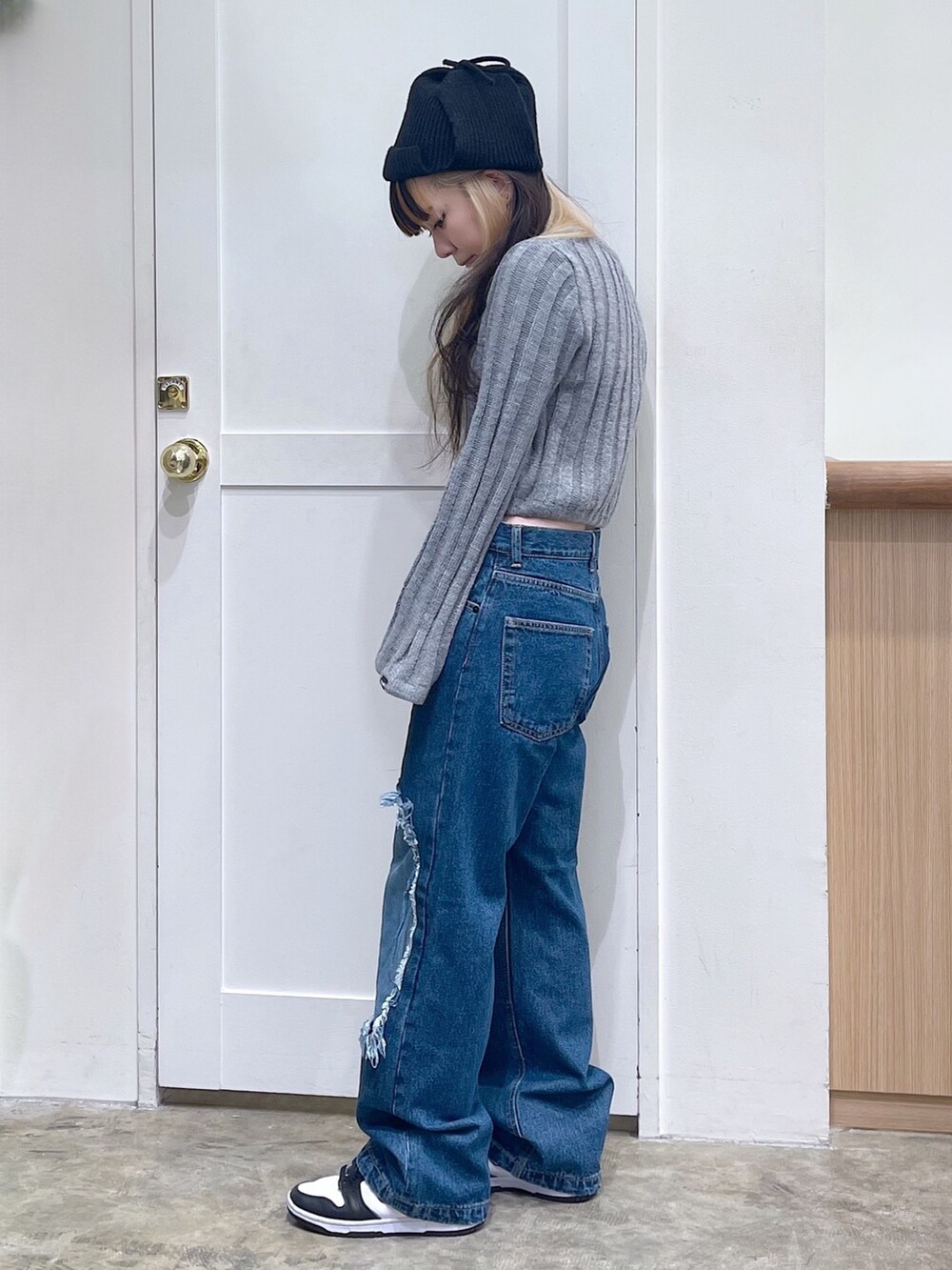 グレー系のニット/セーター、ブルー系のデニムパンツ、ブラック系のニットキャップ/ビーニーを着用したレディースの秋コーディネートの3枚目の写真