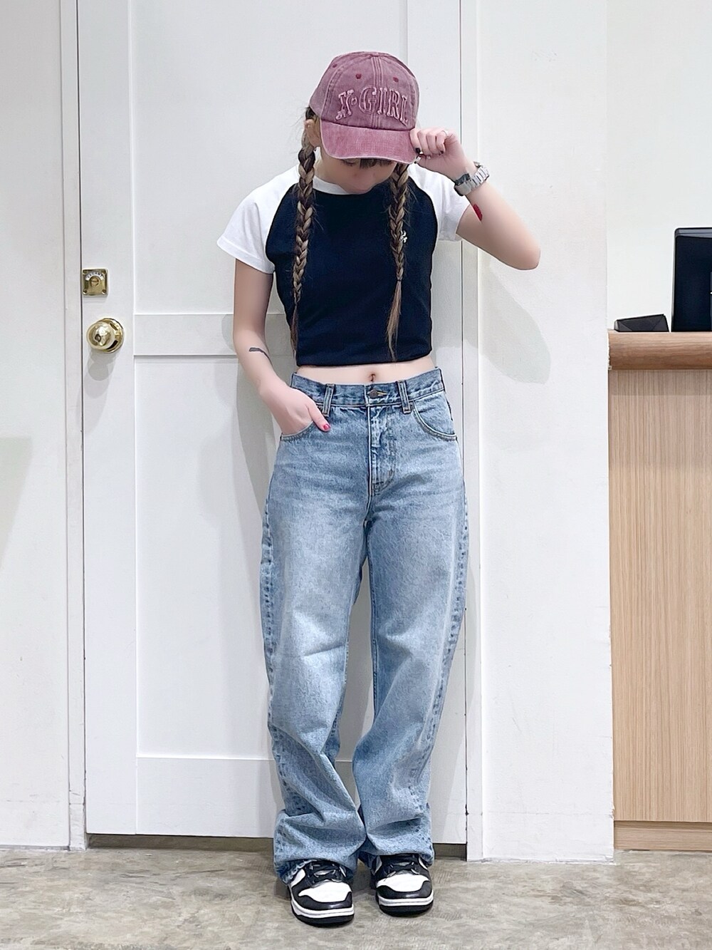 ブラック系のTシャツ/カットソー、ブルー系のデニムパンツ、レッド系のキャップを着用したレディースの夏コーディネートの2枚目の写真