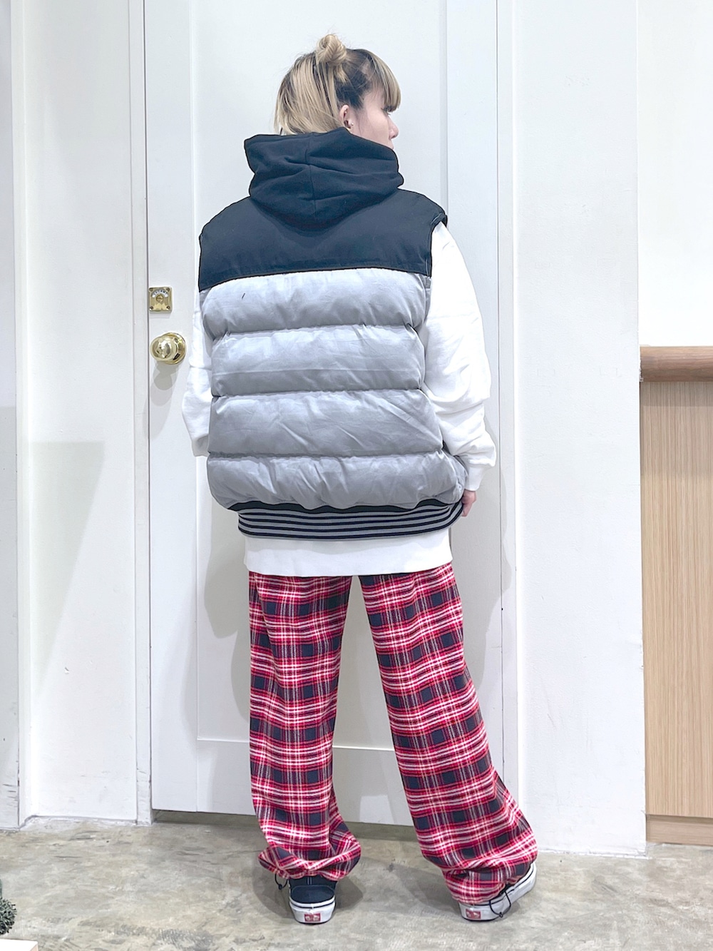 ブラック系のベスト、ホワイト系のパーカー、レッド系のその他パンツを着用したレディースの秋コーディネートの3枚目の写真