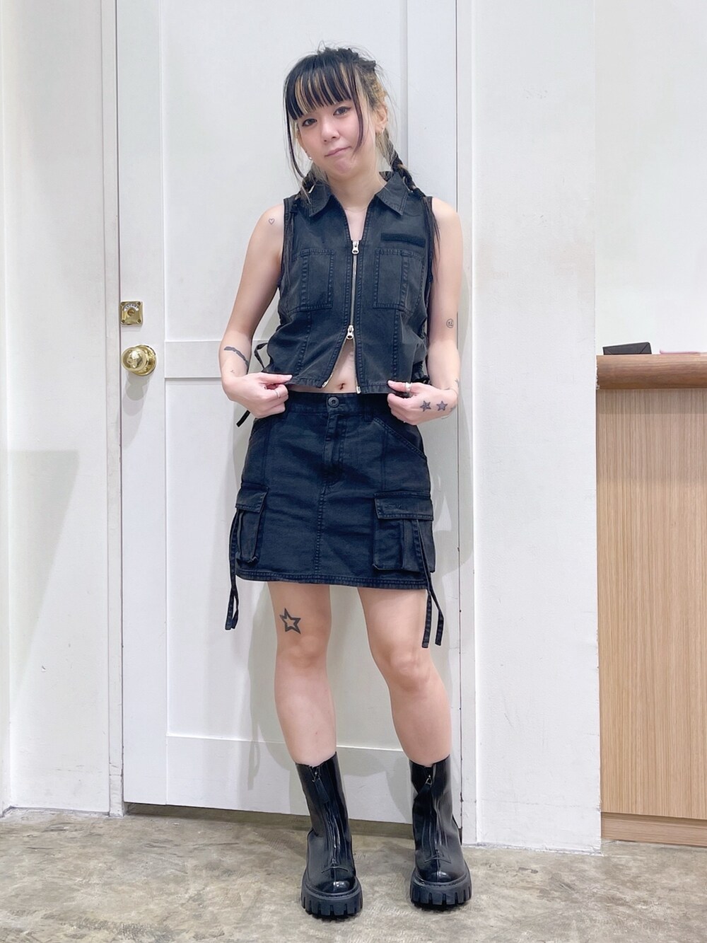 ブラック系のベスト、ブラック系のスカート、ホワイト系のTシャツ/カットソーを着用したレディースの春コーディネートの6枚目の写真