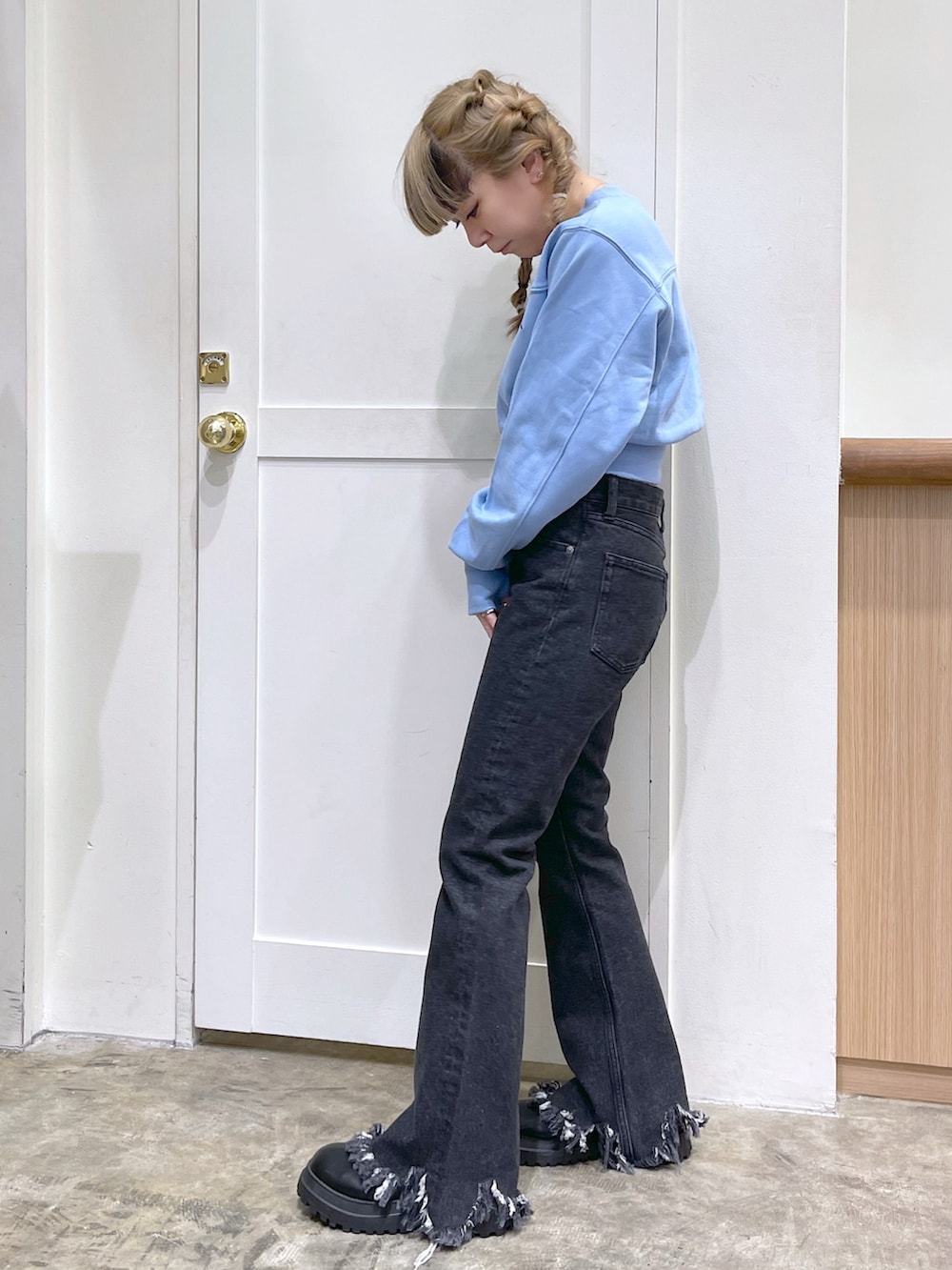 ブルー系のスウェット、ブラック系のデニムパンツ、ブラック系の財布を着用したレディースの冬コーディネートの4枚目の写真