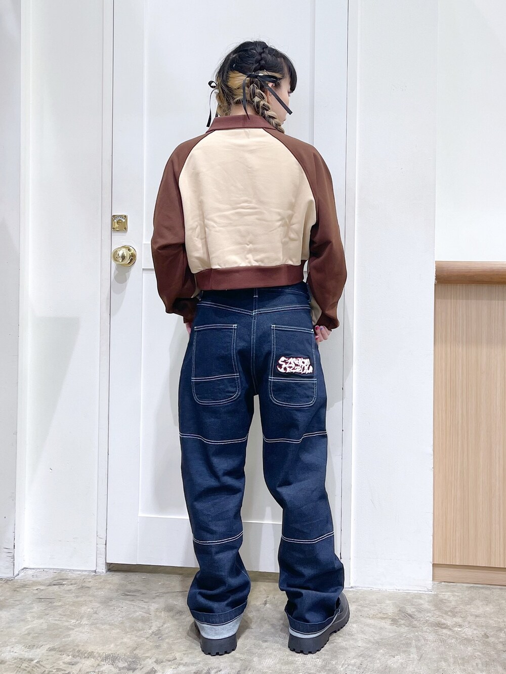 ブラウン系のスウェット、ブルー系のデニムパンツ、イエロー系のハンドバッグを着用したレディースの秋コーディネートの3枚目の写真