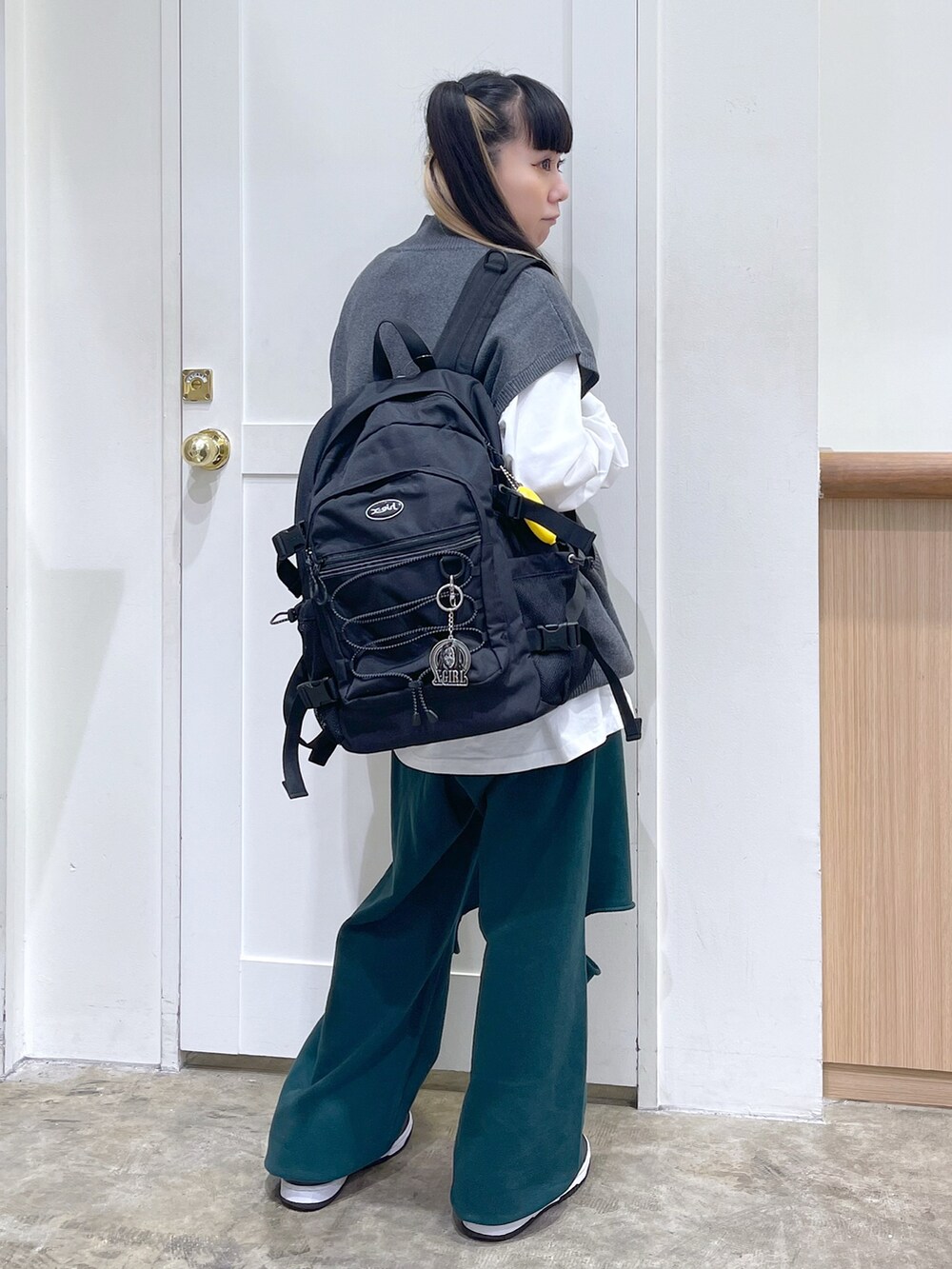 グレー系のベスト、ホワイト系のTシャツ/カットソー、グリーン系のスウェットパンツを着用したレディースの秋コーディネートの2枚目の写真