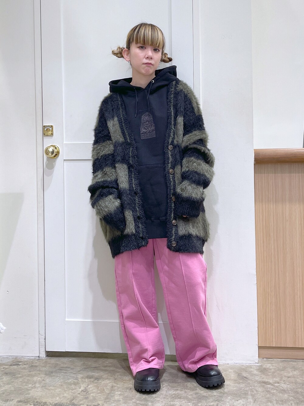 ブラック系のカーディガン/ボレロ、ブラック系のパーカー、ピンク系のスウェットパンツを着用したレディースの冬コーディネートの2枚目の写真
