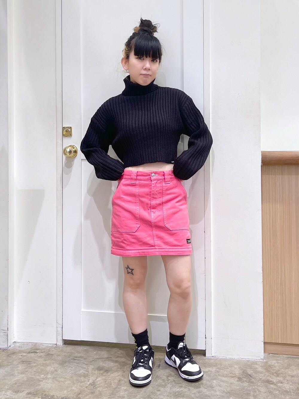 ブラック系のニット/セーター、シルバー系のショルダーバッグ、ピンク系のスカートを着用したレディースの秋コーディネートの6枚目の写真