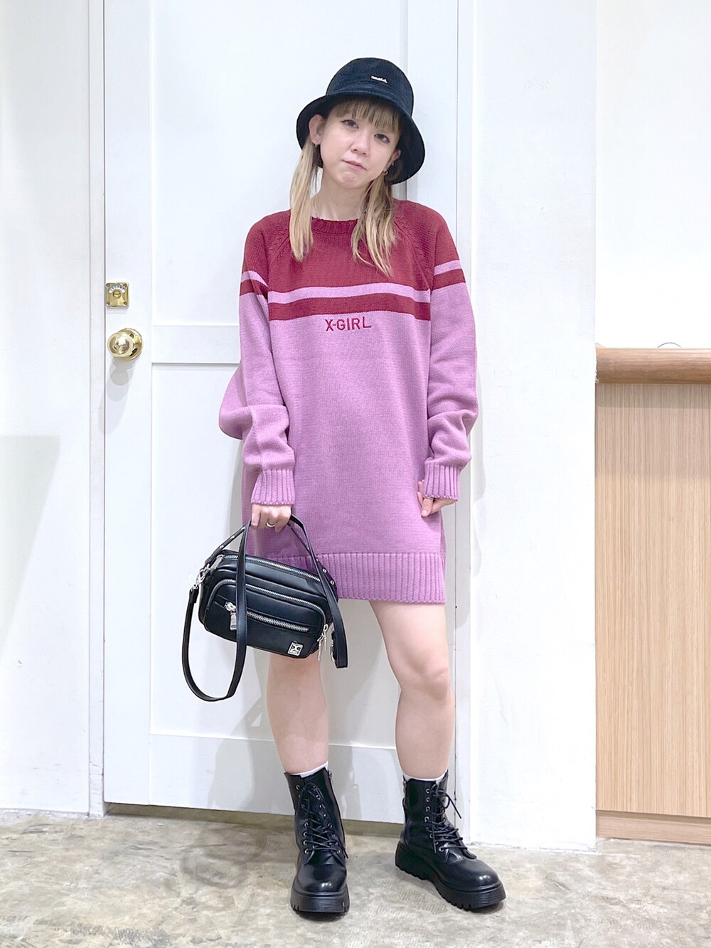 ピンク系のワンピース、ブラック系のショルダーバッグ、ブラック系のハットを着用したレディースの秋コーディネートの2枚目の写真