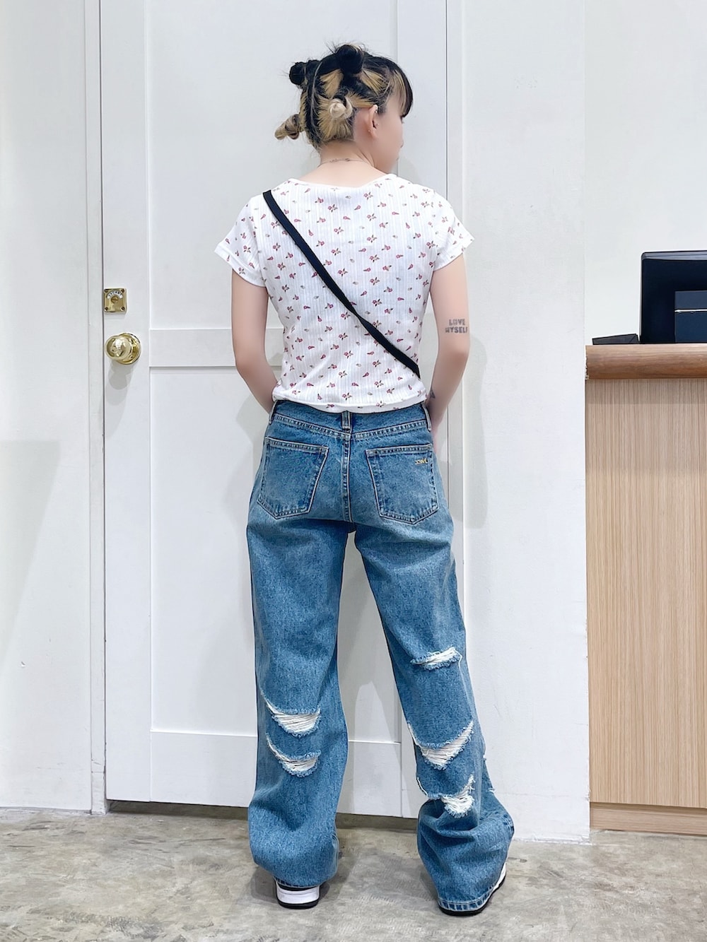 ホワイト系のTシャツ/カットソー、ブルー系のデニムパンツ、ブラック系のショルダーバッグを着用したレディースの夏コーディネートの3枚目の写真