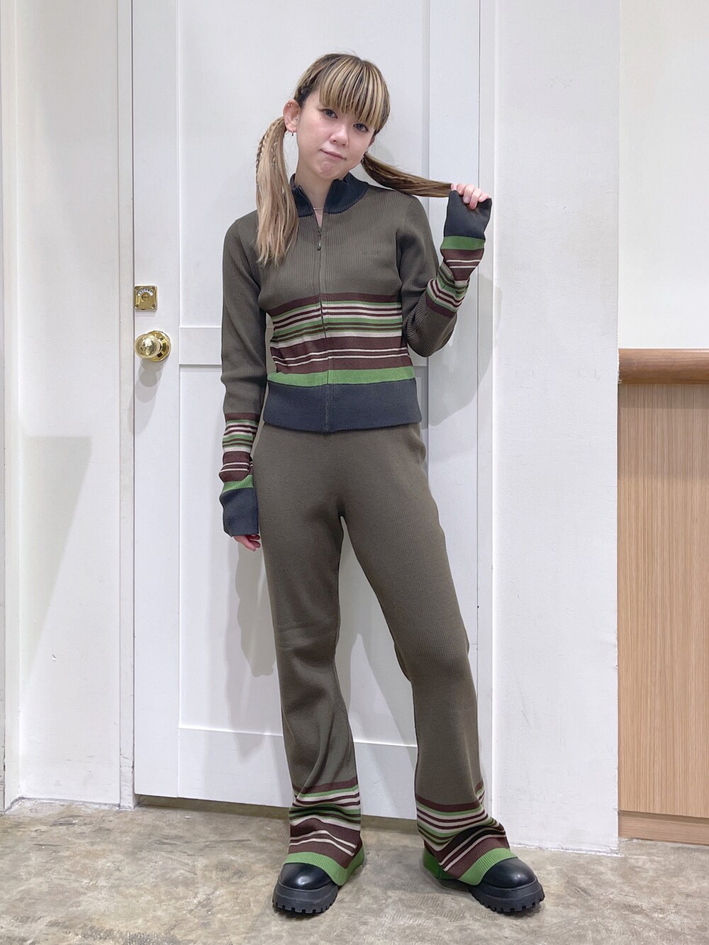 ブラック系のライダースジャケット、グリーン系のカーディガン/ボレロ、グリーン系のその他パンツを着用したレディースの秋コーディネートの4枚目の写真