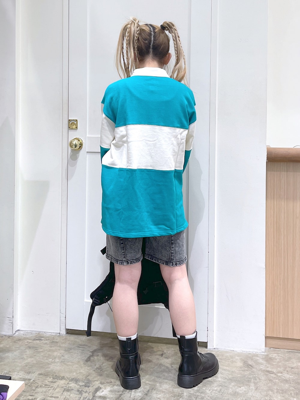 グリーン系のスウェット、ブラック系のバックパック/リュック、ブラック系のデニムパンツを着用したレディースの秋コーディネートの4枚目の写真