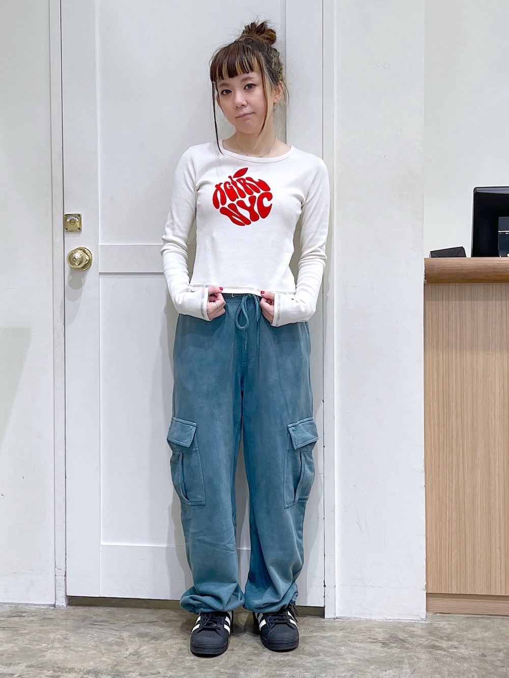 ブラック系のナイロンジャケット、ホワイト系のTシャツ/カットソー、ブルー系のスウェットパンツを着用したレディースの秋コーディネートの5枚目の写真