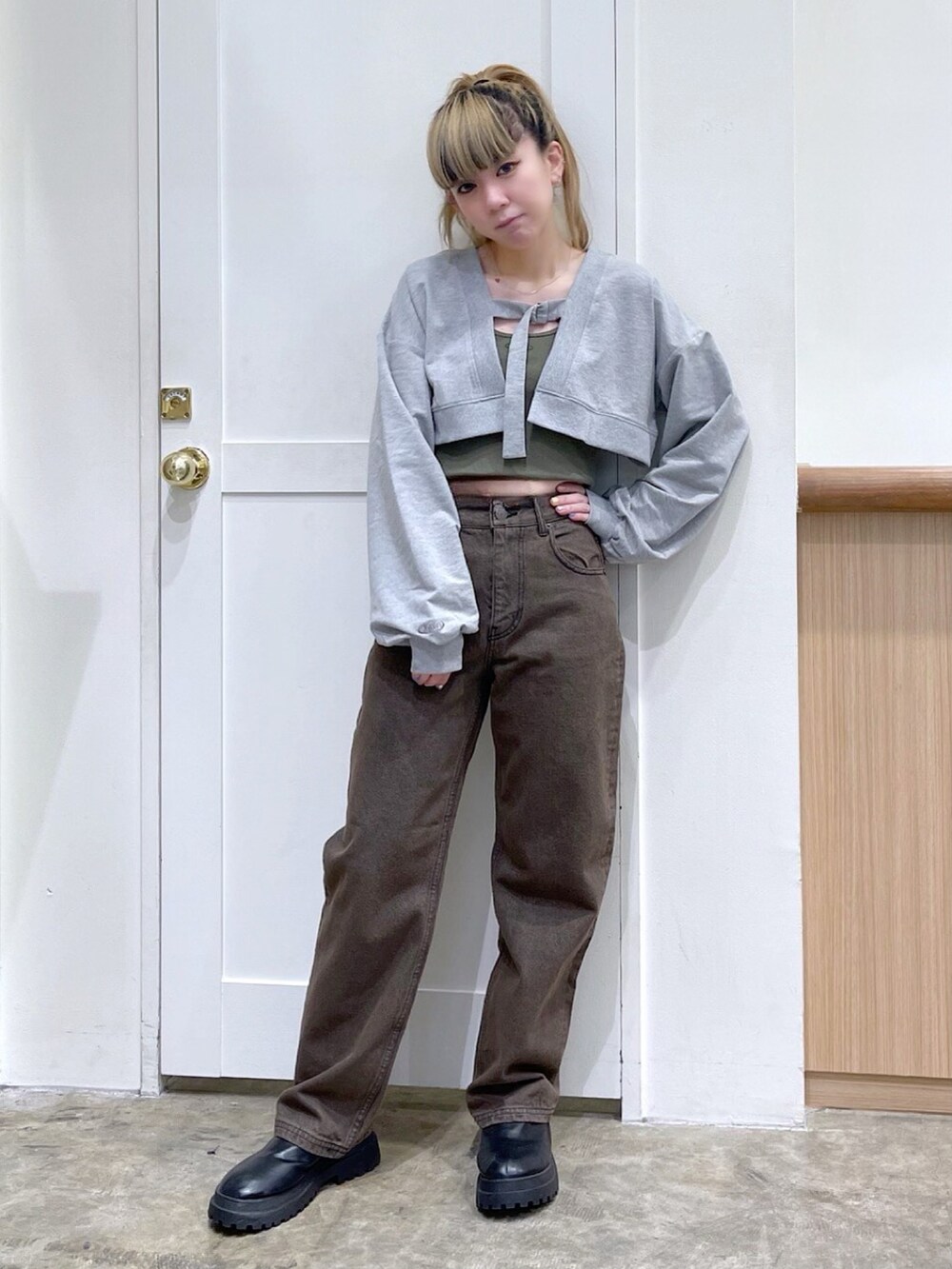 グレー系のトップス、グリーン系のトップス、ブラウン系のデニムパンツを着用したレディースの春コーディネートの2枚目の写真