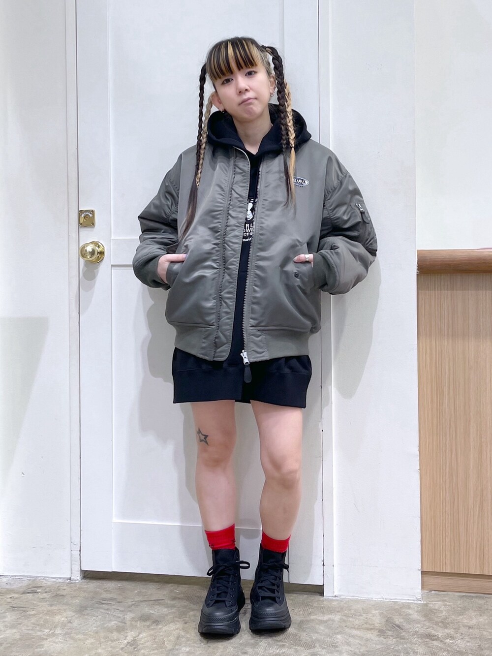 グリーン系のMA-1、ブラック系のパーカー、ブラック系のショルダーバッグを着用したレディースの冬コーディネートの3枚目の写真