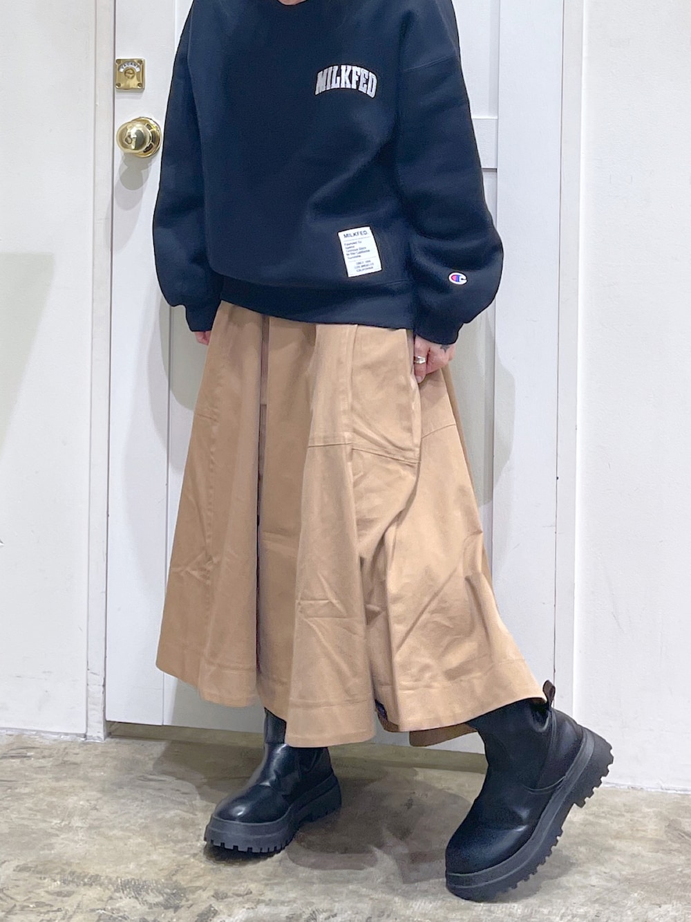 ブラック系のスウェット、ベージュ系のスカート、ブラック系のボディバッグ/ウエストポーチを着用したレディースの秋コーディネートの5枚目の写真