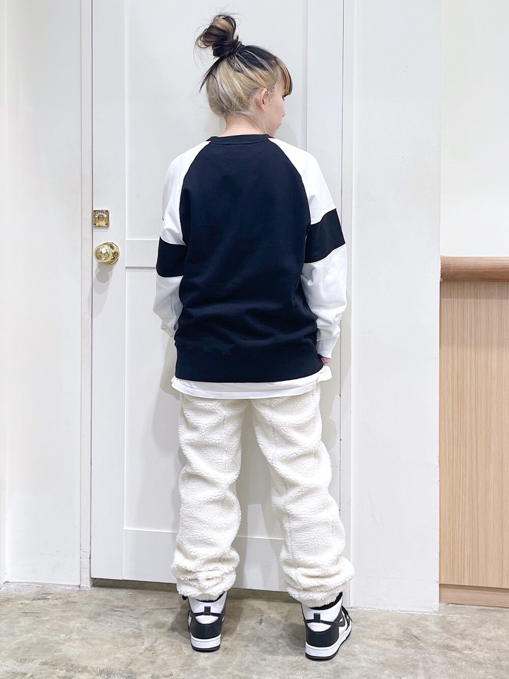 グレー系のマウンテンパーカー、ブラック系のスウェット、ホワイト系のその他パンツを着用したレディースの秋コーディネートの8枚目の写真