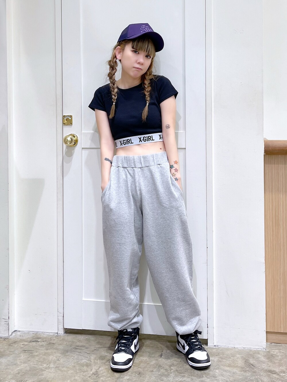 グレー系のスウェットパンツ、ブラック系のTシャツ/カットソー、ホワイト系のスニーカーを着用したレディースの春コーディネートの2枚目の写真