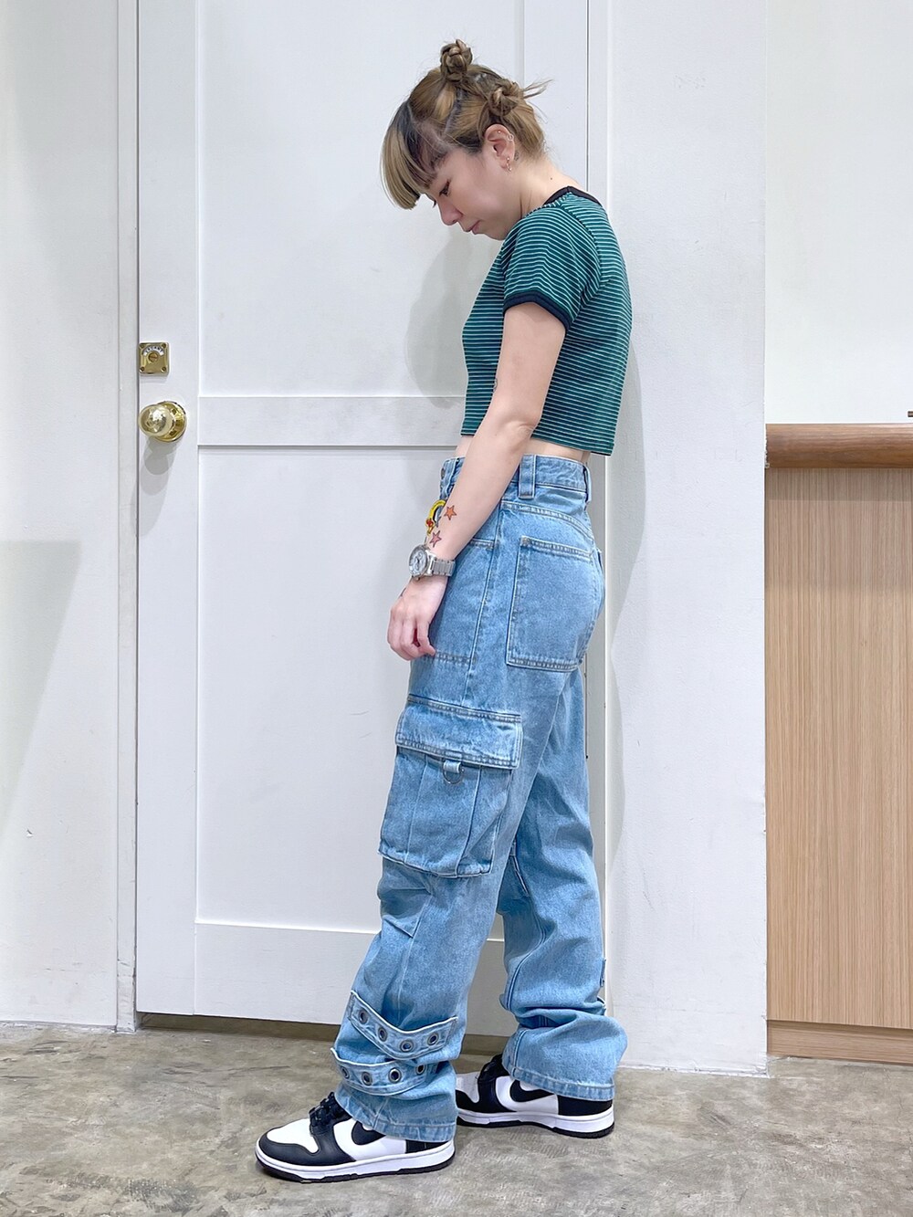 グリーン系のTシャツ/カットソー、ブルー系のカーゴパンツ、ホワイト系のバックパック/リュックを着用したレディースの春コーディネートの3枚目の写真