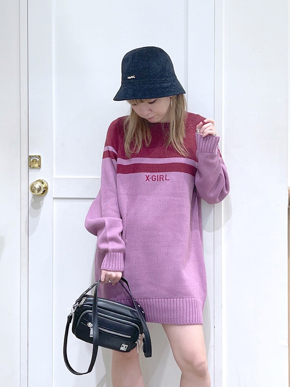 ピンク系のワンピース、ブラック系のショルダーバッグ、ブラック系のハットを着用したレディースの秋コーディネートの5枚目の写真