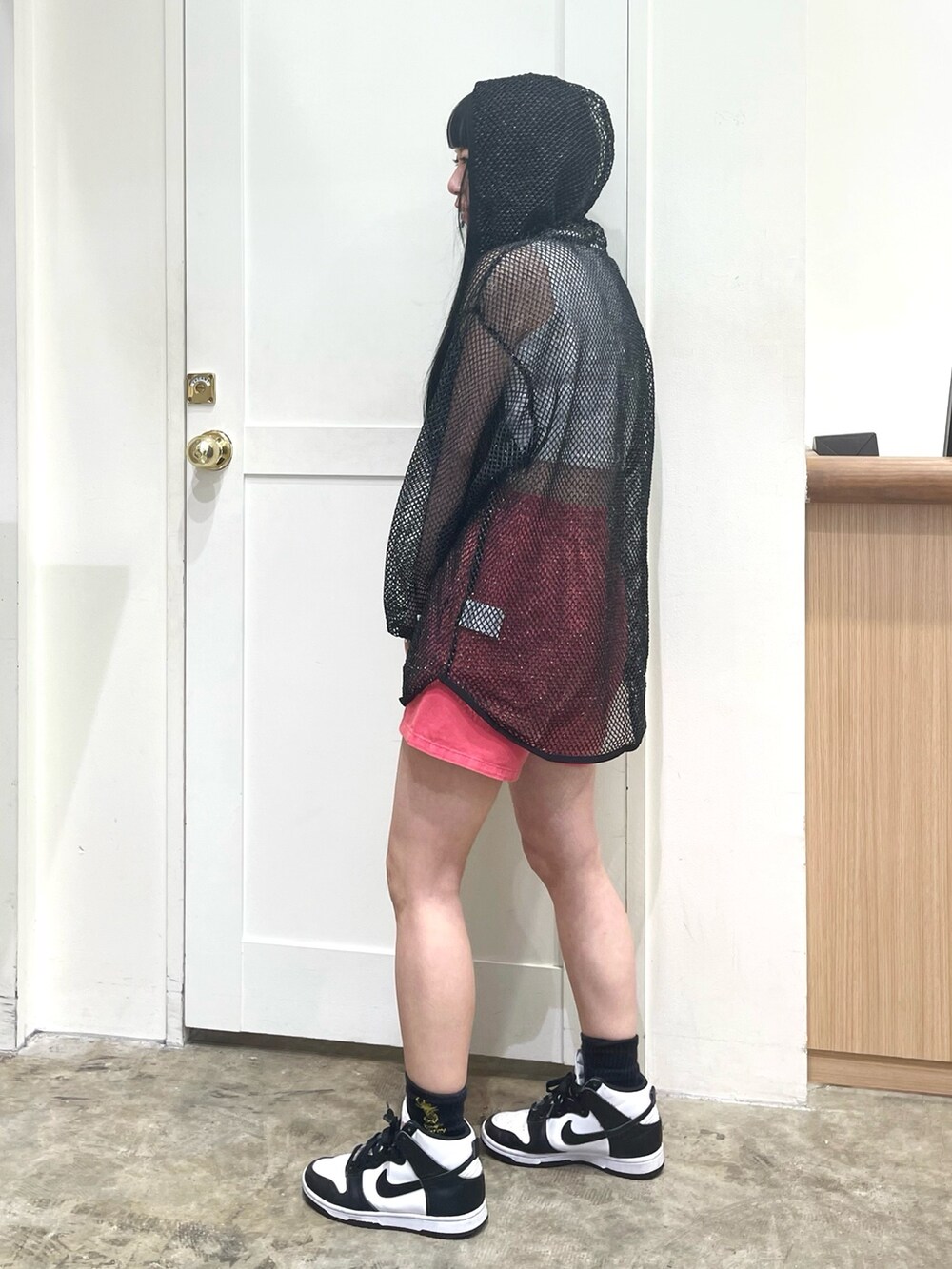 ブラック系のパーカー、ホワイト系のタンクトップ、レッド系のその他パンツを着用したレディースの春コーディネートの3枚目の写真