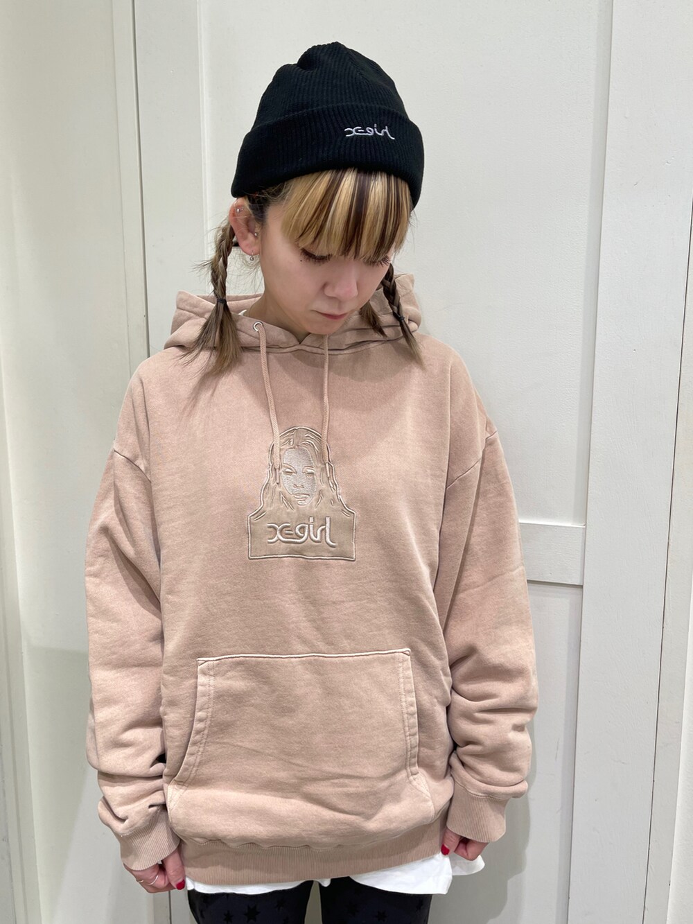 ベージュ系のパーカー、ブラック系のその他パンツ、ブラック系のニットキャップ/ビーニーを着用したレディースの冬コーディネートの2枚目の写真