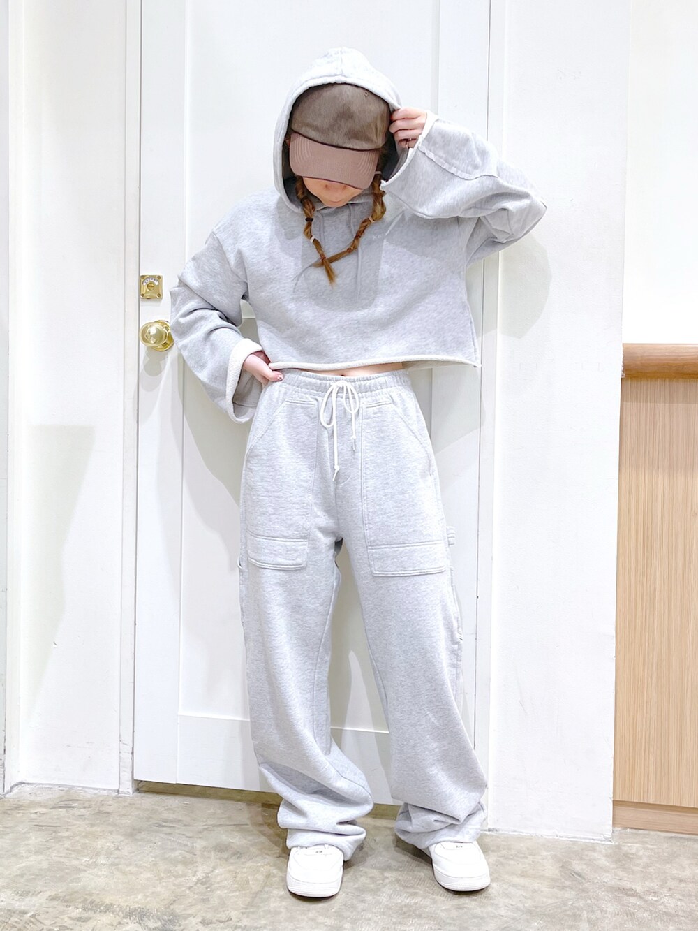 グレー系のパーカー、グレー系のスウェットパンツ、ブラウン系のキャップを着用したレディースの冬コーディネートの2枚目の写真