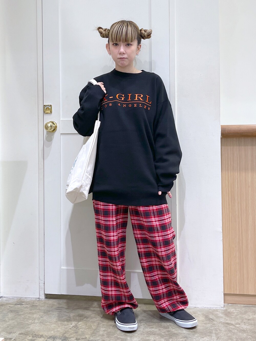 レッド系のシャツ/ブラウス、ブラック系のニット/セーター、ホワイト系のトートバッグを着用したレディースの秋コーディネートの4枚目の写真