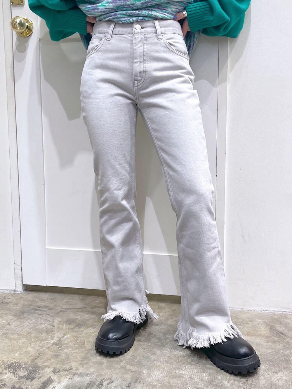 グリーン系のニット/セーター、ベージュ系のデニムパンツ、ブラック系のマフラーを着用したレディースの冬コーディネートの5枚目の写真