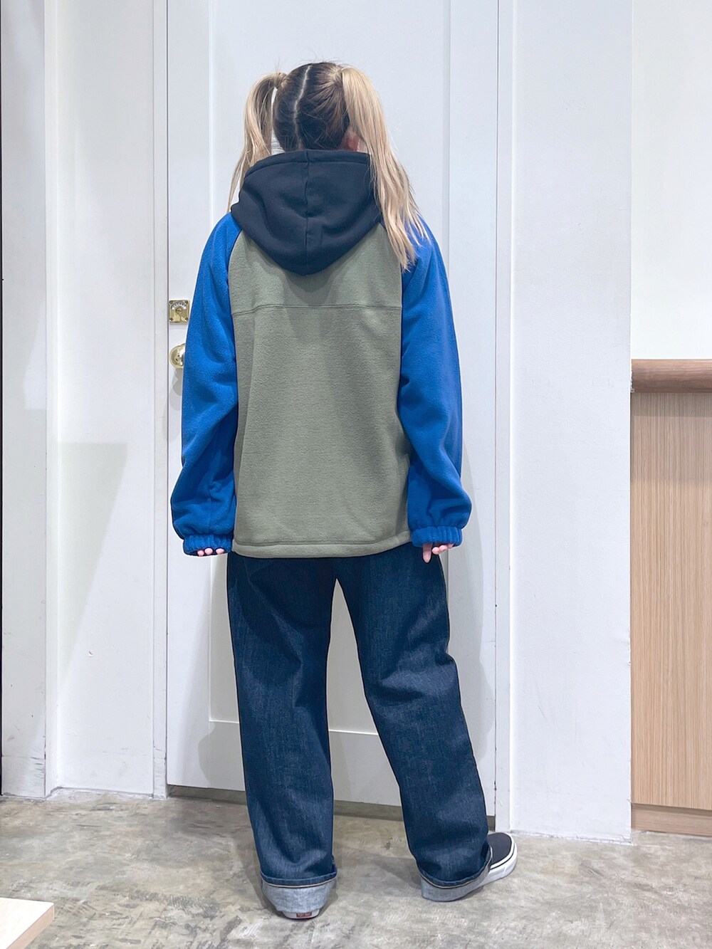 ブルー系のブルゾン、ホワイト系のパーカー、ブルー系のデニムパンツを着用したレディースの秋コーディネートの3枚目の写真
