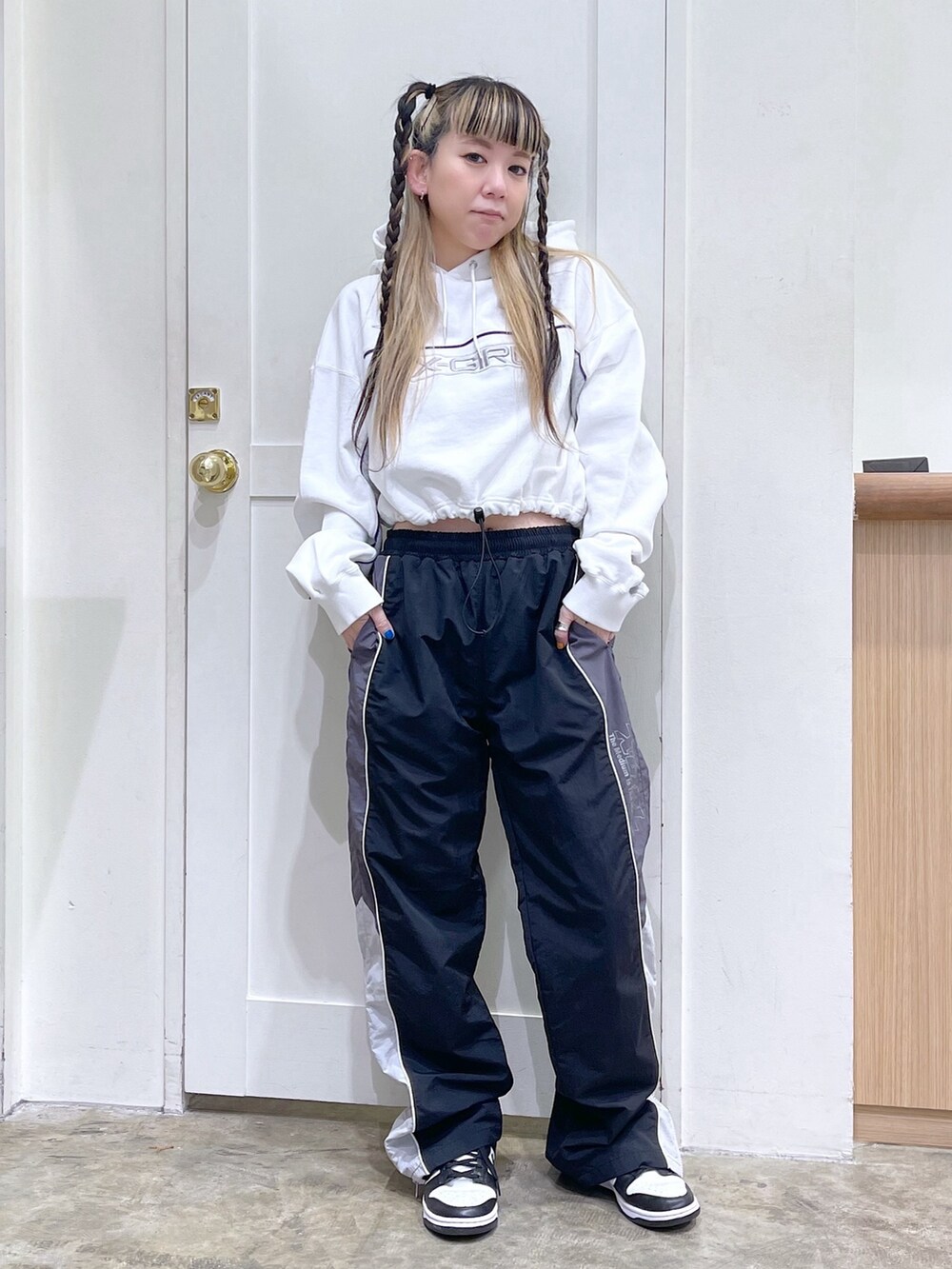 ホワイト系のパーカー、ブラック系のその他パンツ、ブルー系のショルダーバッグを着用したレディースの春コーディネートの2枚目の写真