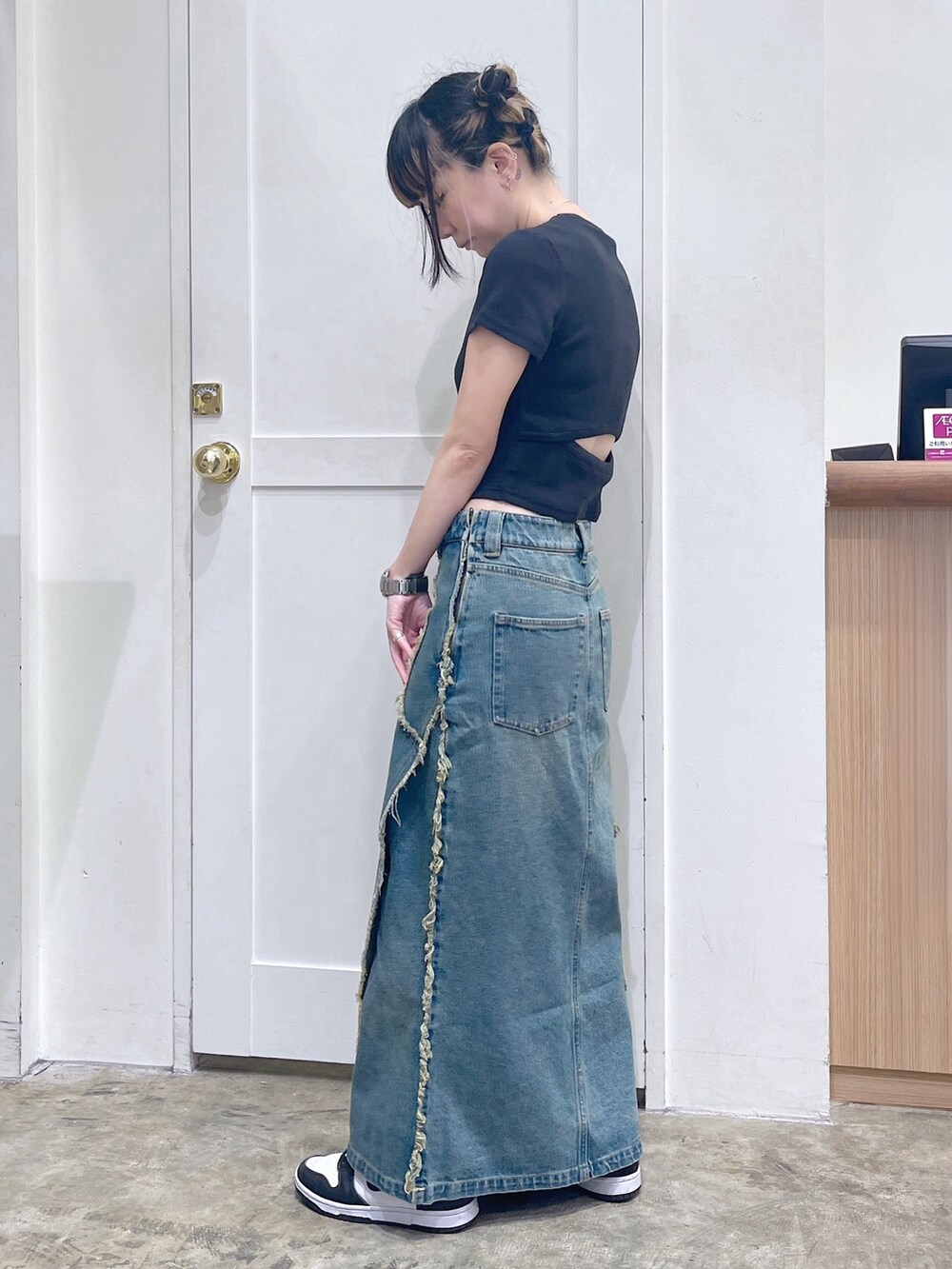 ブラック系のTシャツ/カットソー、ブルー系のデニムスカート、ブルー系のショルダーバッグを着用したレディースの夏コーディネートの3枚目の写真