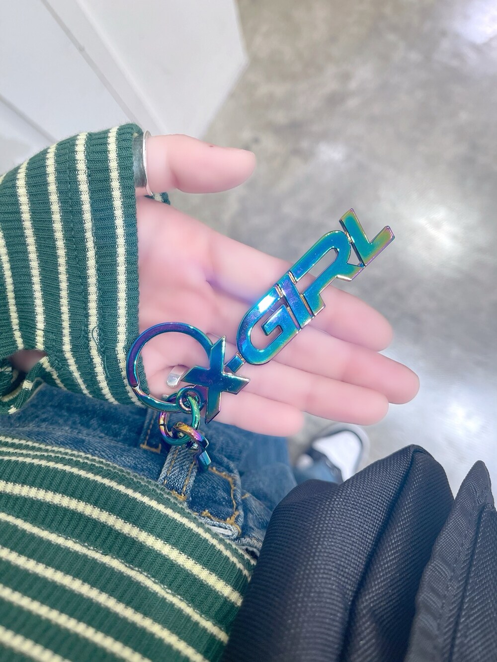 グリーン系のTシャツ/カットソー、ブルー系のデニムパンツ、ブラック系のショルダーバッグを着用したレディースの冬コーディネートの5枚目の写真