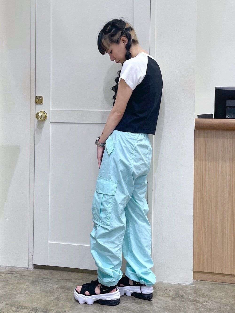 ブラック系のTシャツ/カットソー、グリーン系のカーゴパンツ、ブラック系のサンダルを着用したレディースの夏コーディネートの2枚目の写真