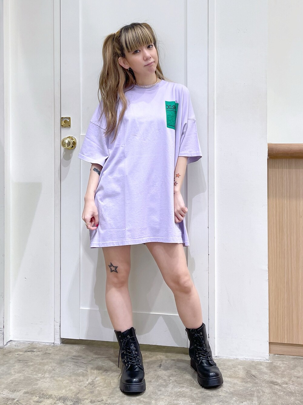 パープル系のワンピース、ブラック系のデニムパンツ、ゴールド系のチョーカーを着用したレディースの春コーディネートの2枚目の写真