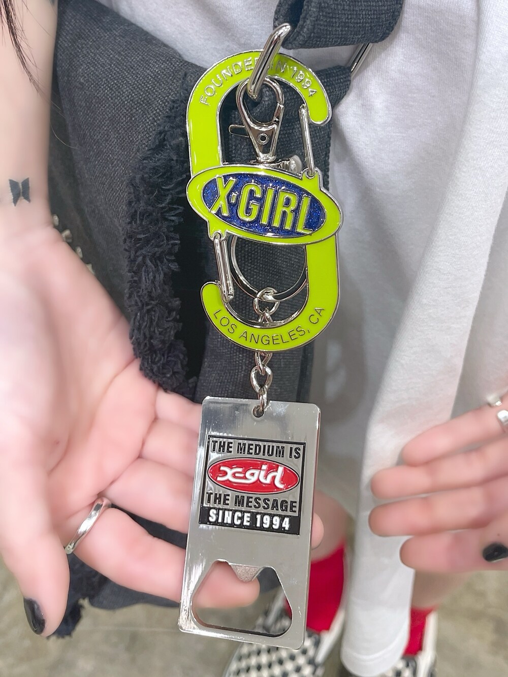 ホワイト系のワンピース、ブラック系のショルダーバッグ、グリーン系のキーケース/キーアクセサリーを着用したレディースの夏コーディネートの4枚目の写真