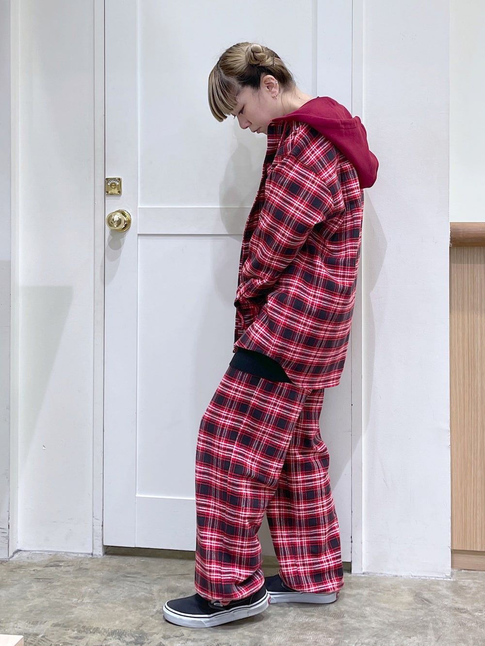 レッド系のシャツ/ブラウス、ブラック系のニット/セーター、ホワイト系のトートバッグを着用したレディースの秋コーディネートの2枚目の写真