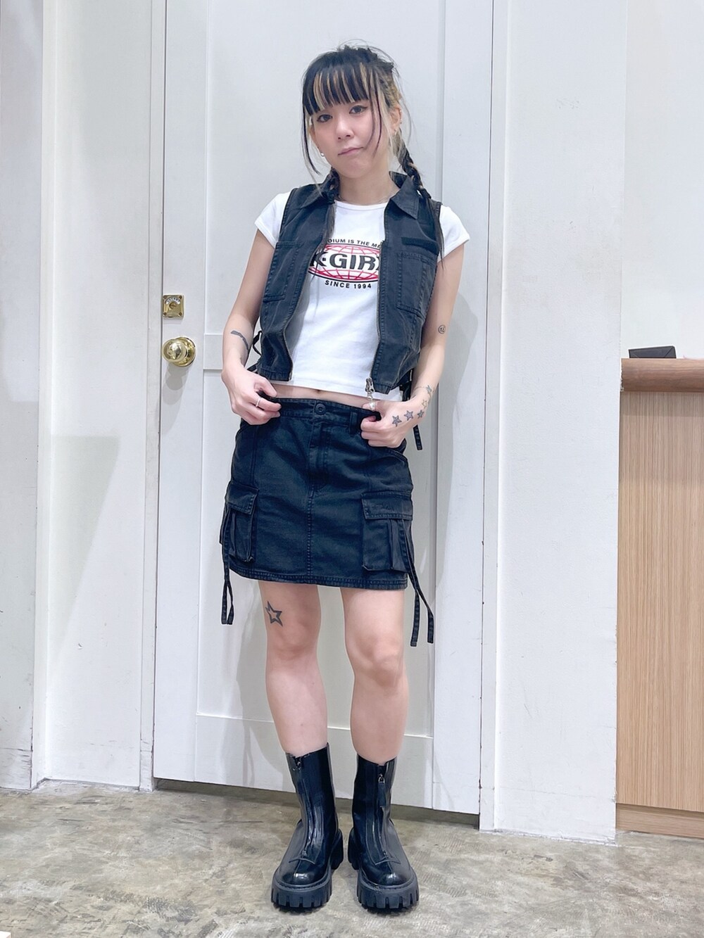 ブラック系のベスト、ブラック系のスカート、ホワイト系のTシャツ/カットソーを着用したレディースの春コーディネートの3枚目の写真