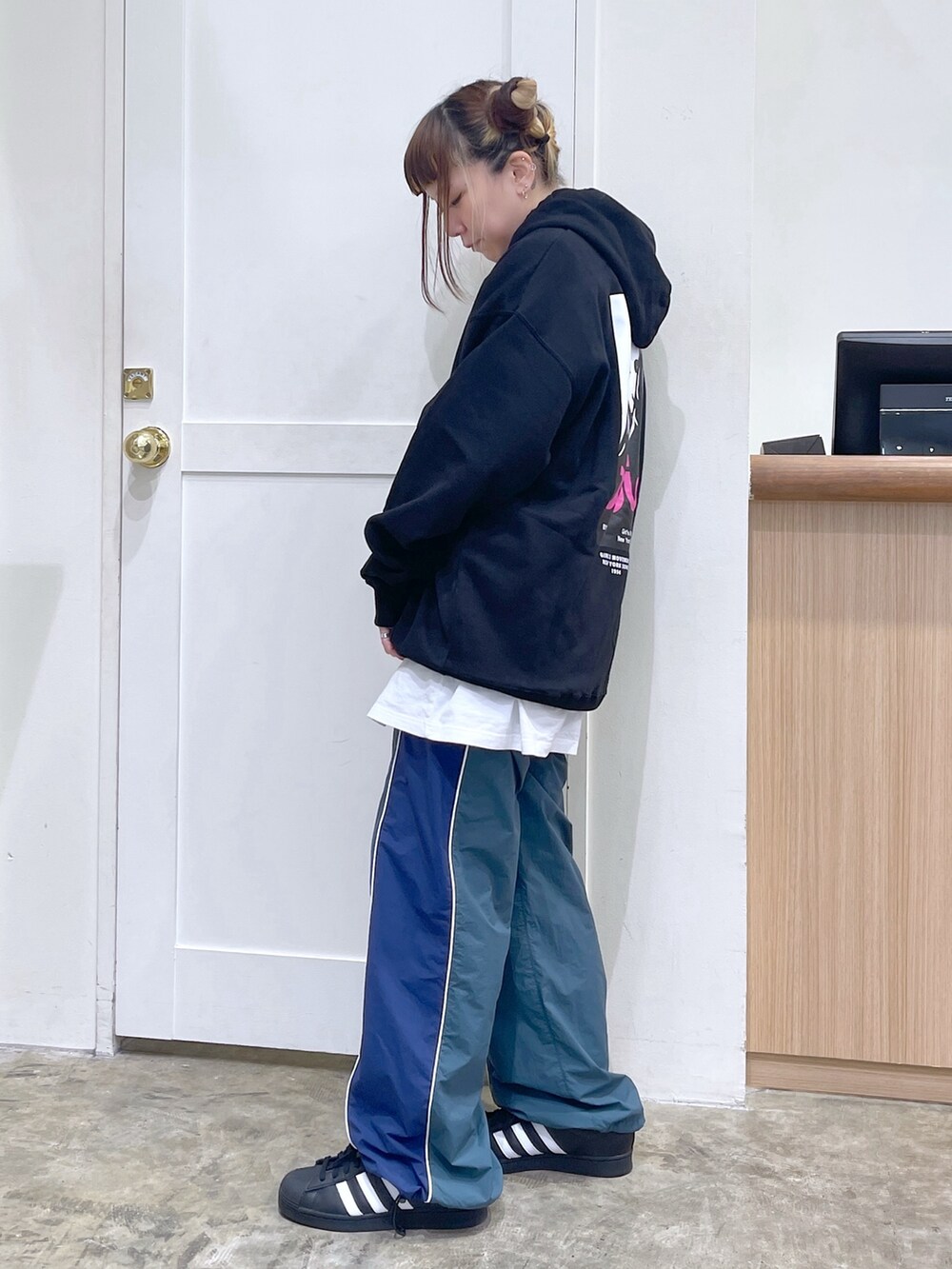 ブラック系のパーカー、グリーン系のその他パンツ、ブルー系のトートバッグを着用したレディースの秋コーディネートの4枚目の写真