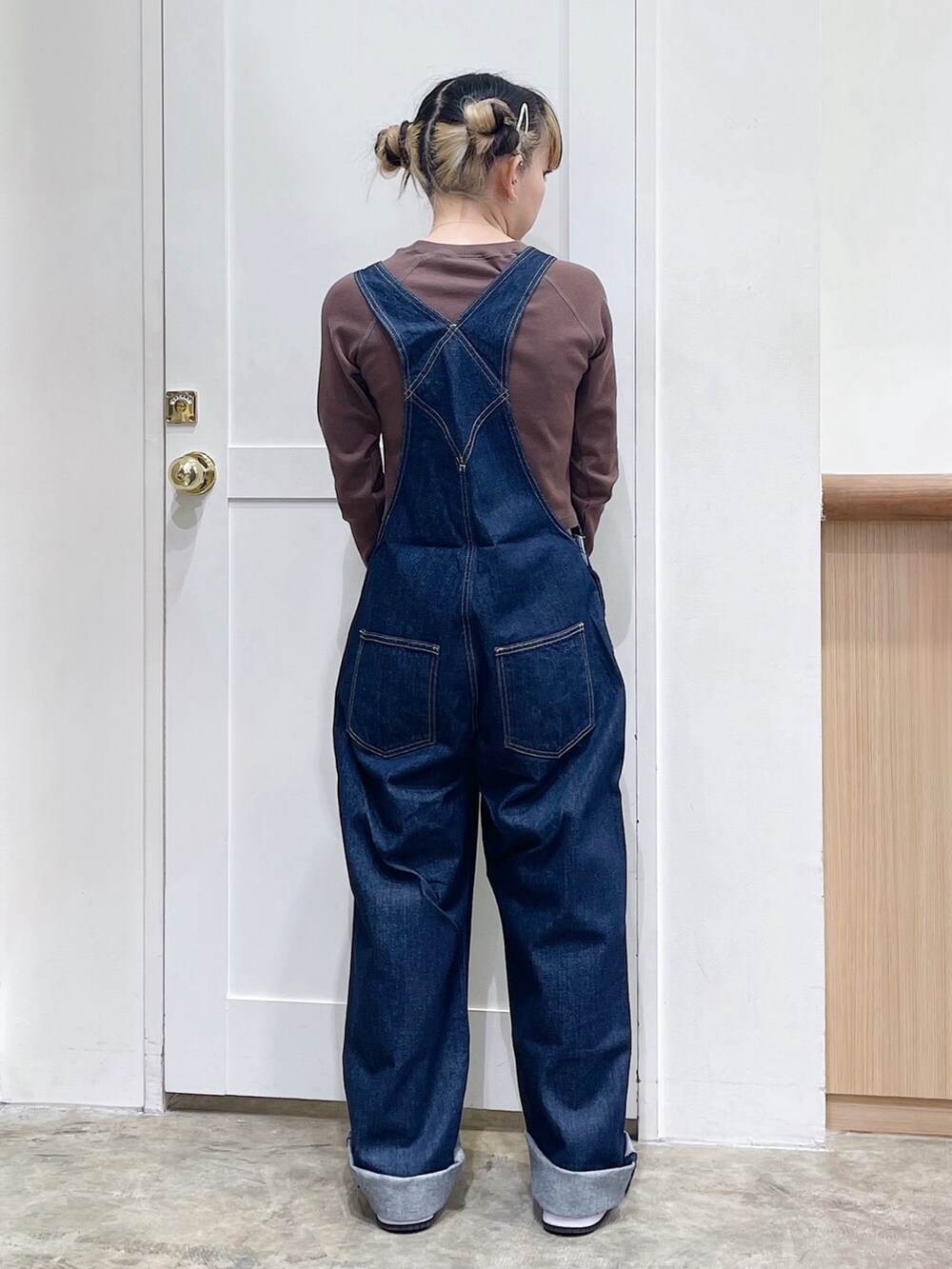 グリーン系のパーカー、ブルー系のサロペット/オーバーオール、ブラウン系のTシャツ/カットソーを着用したレディースの冬コーディネートの7枚目の写真