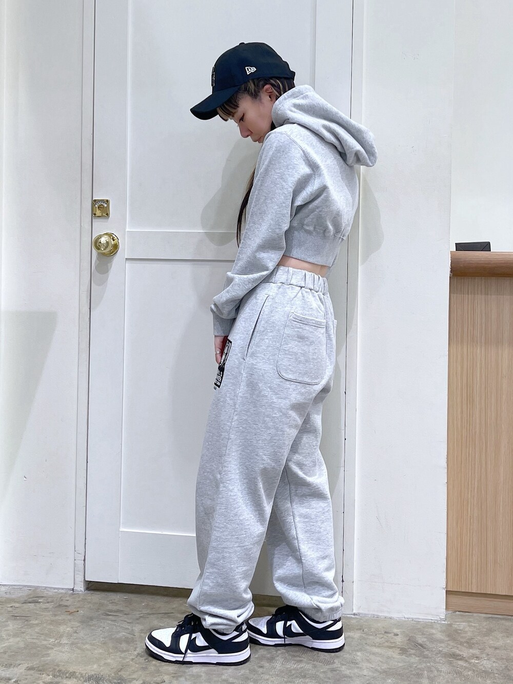 グレー系のパーカー、グレー系のスウェットパンツ、ブラック系のキャップを着用したレディースの春コーディネートの2枚目の写真