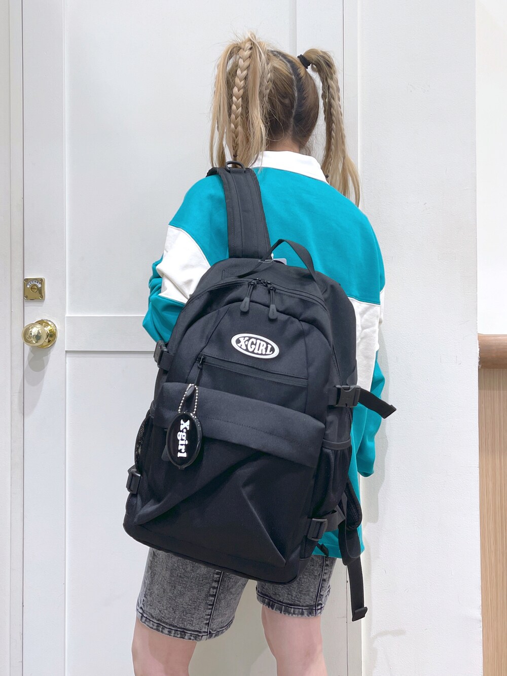 グリーン系のスウェット、ブラック系のバックパック/リュック、ブラック系のデニムパンツを着用したレディースの秋コーディネートの5枚目の写真