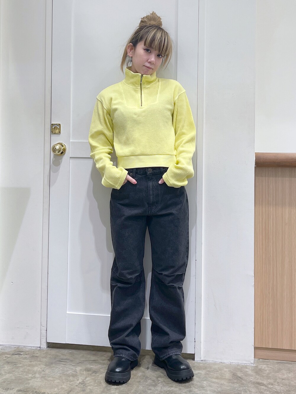 イエロー系のTシャツ/カットソー、ブラック系のショルダーバッグ、ブラック系のデニムパンツを着用したレディースの秋コーディネートの4枚目の写真