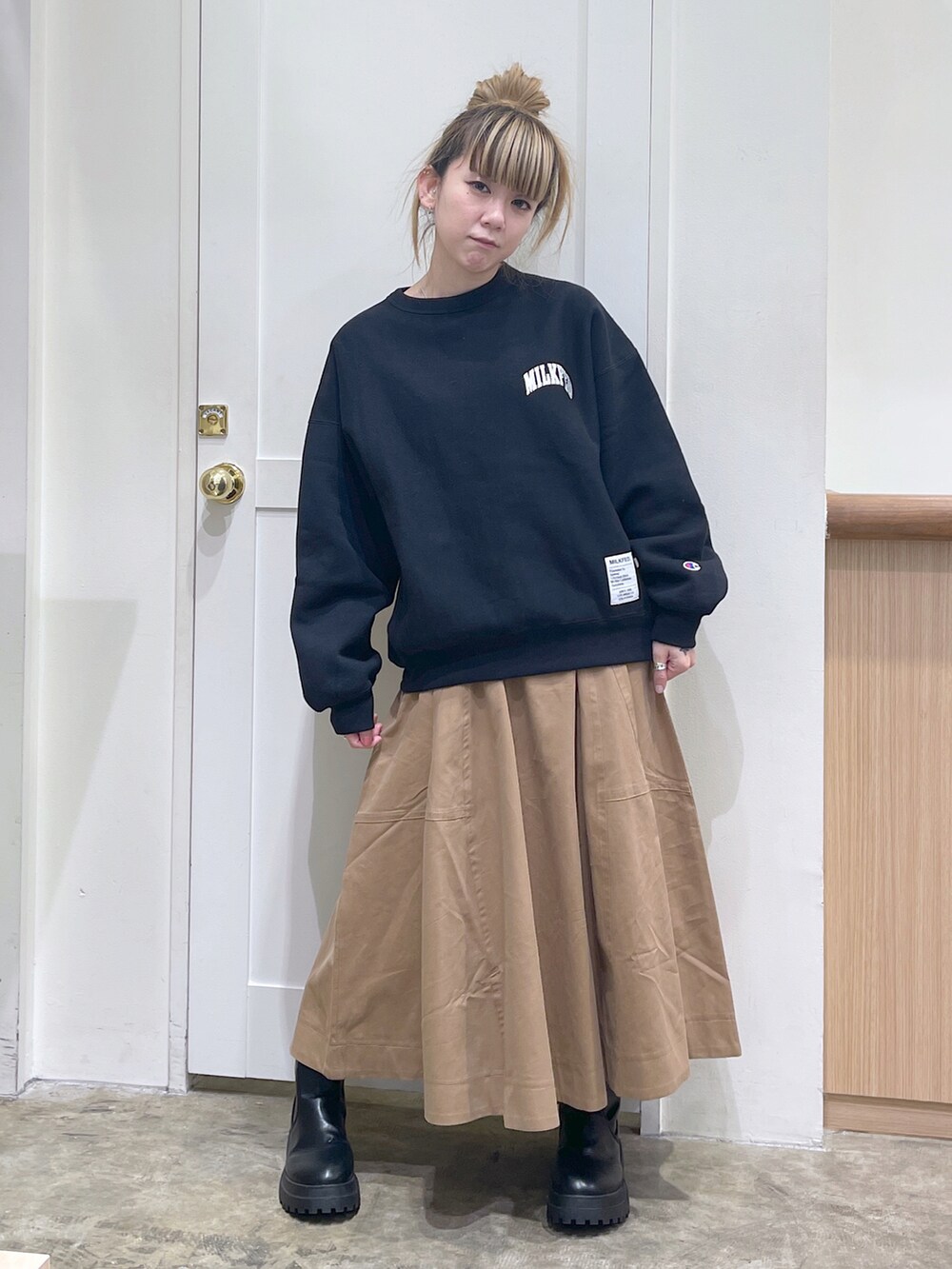 ブラック系のスウェット、ベージュ系のスカート、ブラック系のボディバッグ/ウエストポーチを着用したレディースの秋コーディネートの3枚目の写真