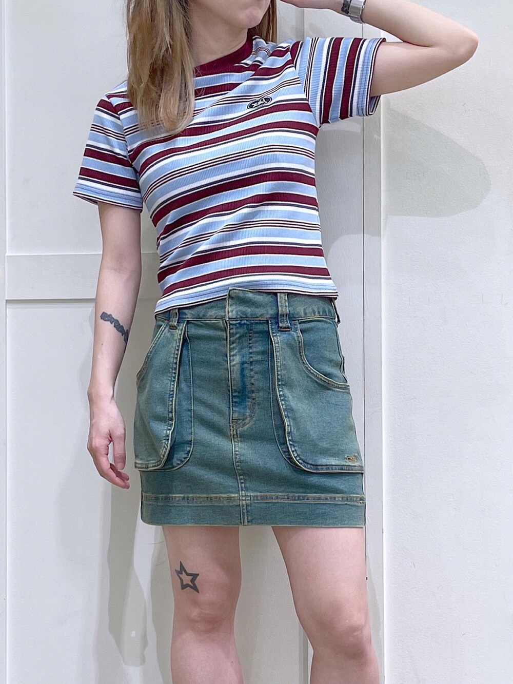 レッド系のTシャツ/カットソー、ブルー系のスカート、ブラック系のサンダルを着用したレディースの夏コーディネートの4枚目の写真